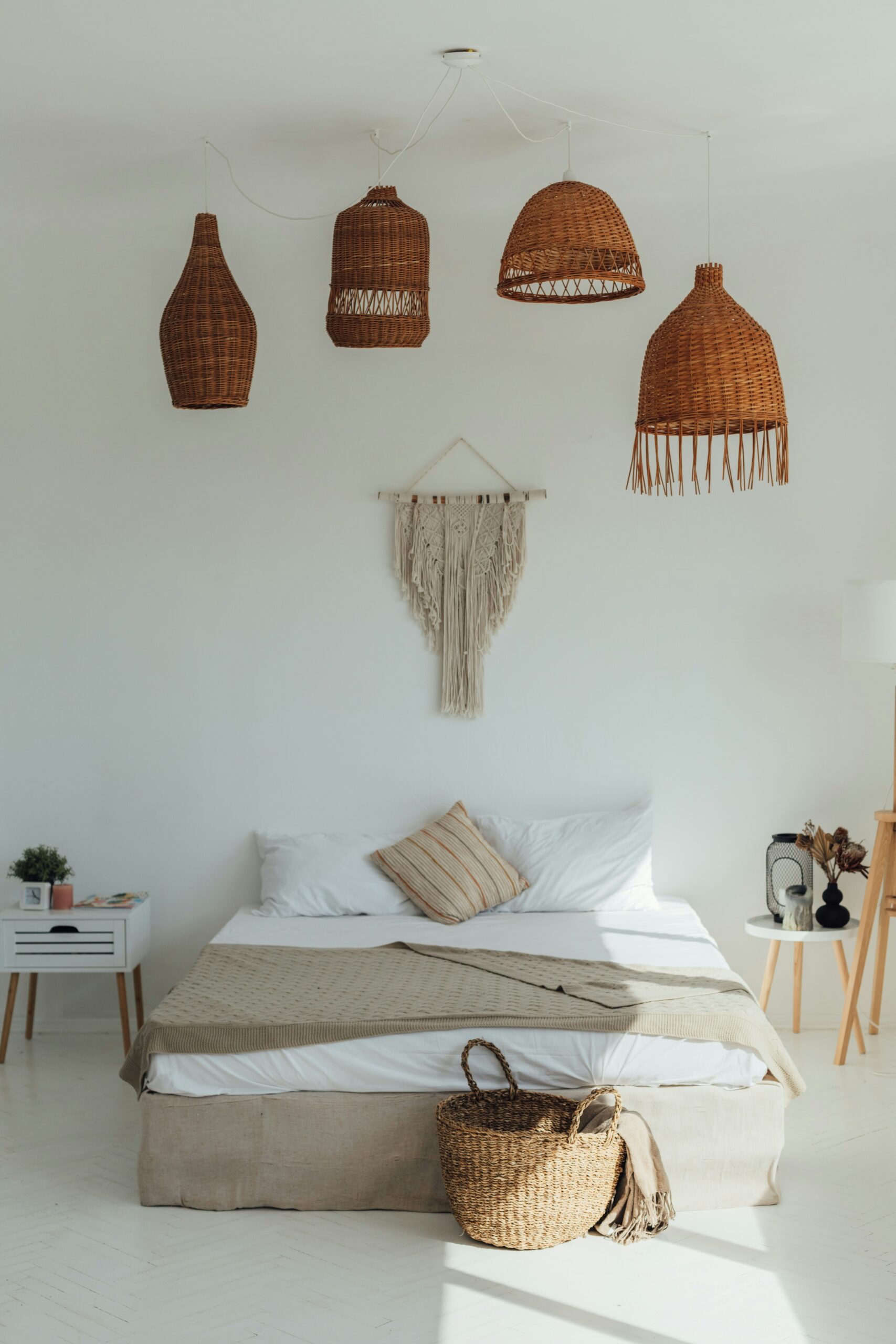 Woven basket used as hidden bedroom storage beside natural materials and plants.