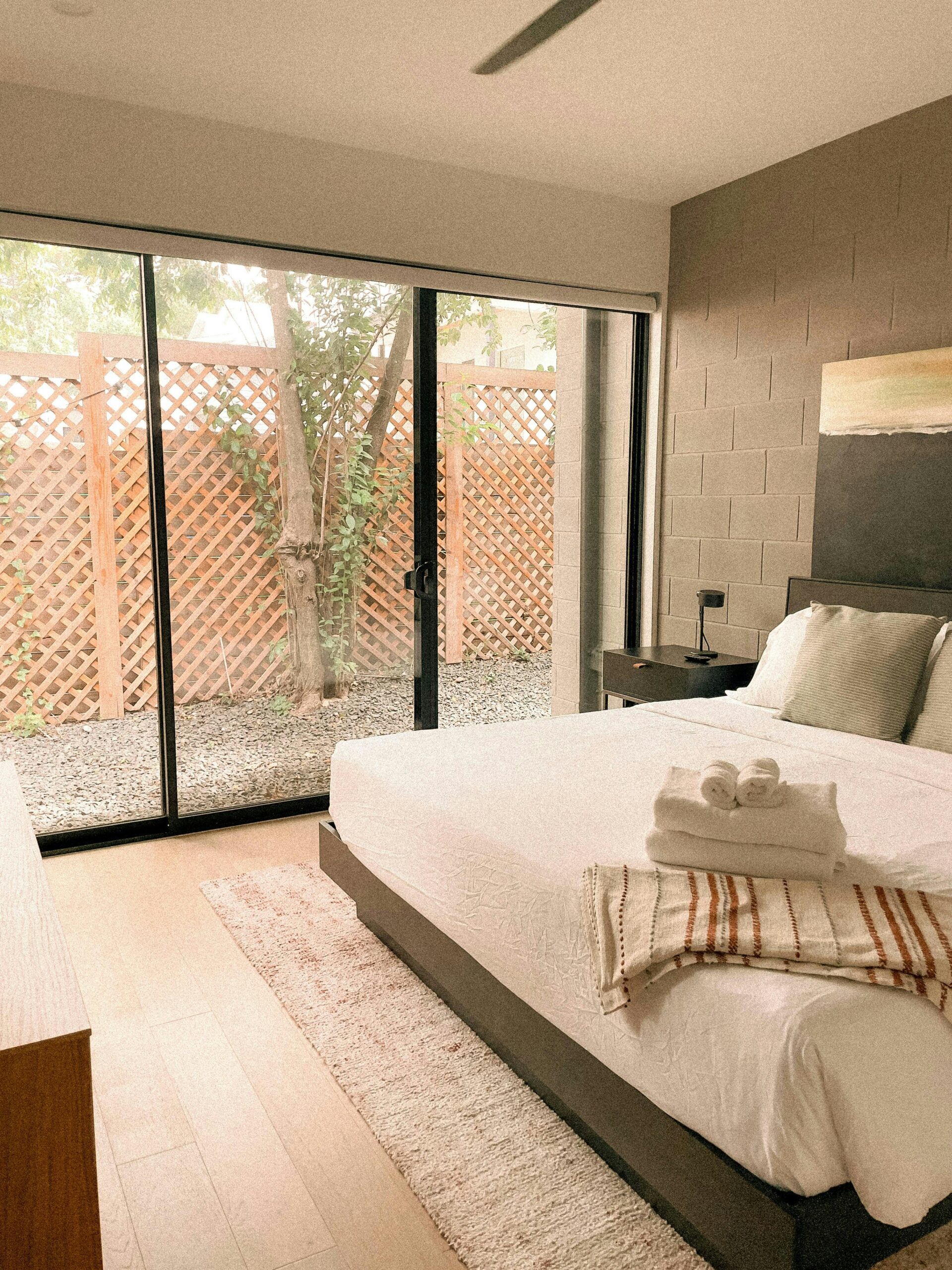 Charcoal accent bedroom with dark wall tones, warm bedding, and calm modern contrast.