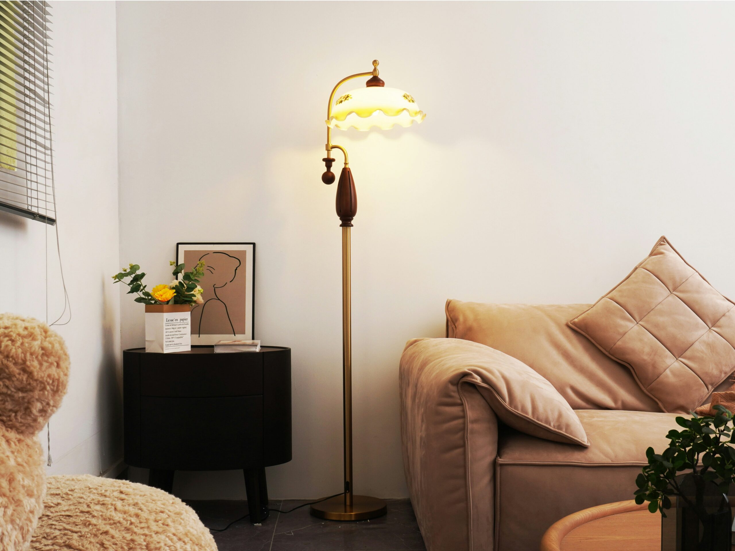 Softly lit Japandi corner with a warm floor lamp, neutral sofa, and calm evening atmosphere.