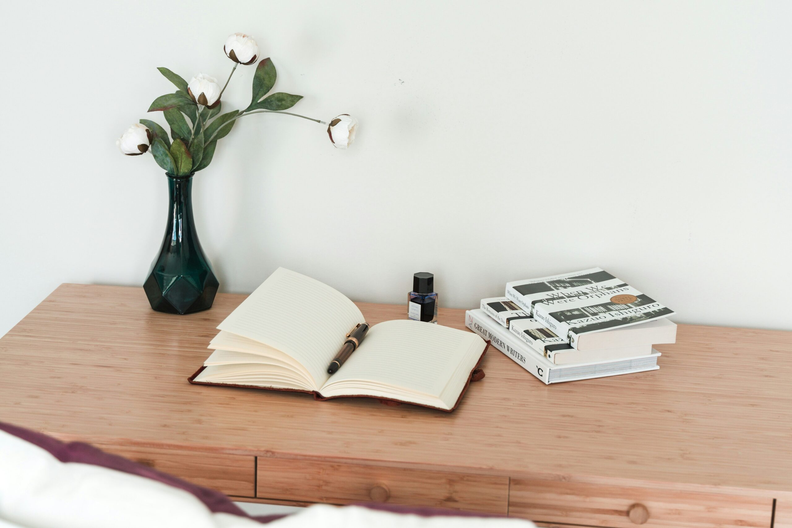 Clean nightstand with only a few essential objects in a calm minimal bedroom.